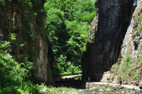 As pessoas ficam minúsculas quando comparadas à ponte de pedra no parque 'Natural Bridge', na Virginia, nos Estados Unidos